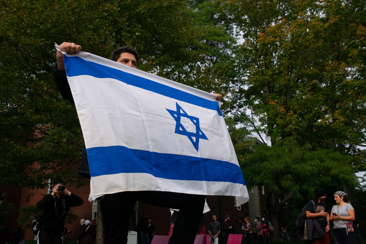 HBS student Raphael C.S. Maarek holds an Israeli flag at the protest.
