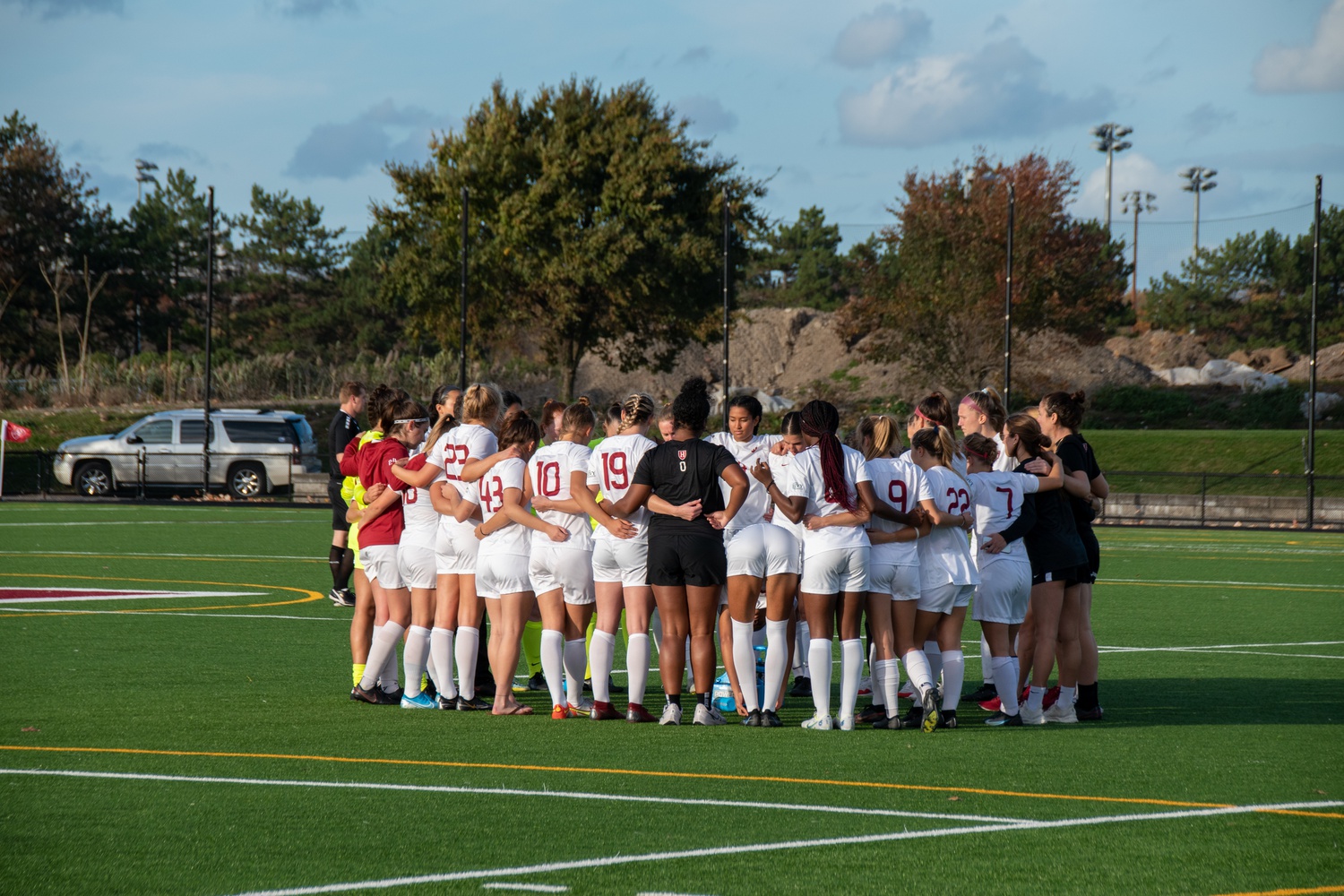 The Harvard women's soccer team huddles in its Nov. 5, 2022 game against Columbia. The Crimson toppled the Lions 5-0.